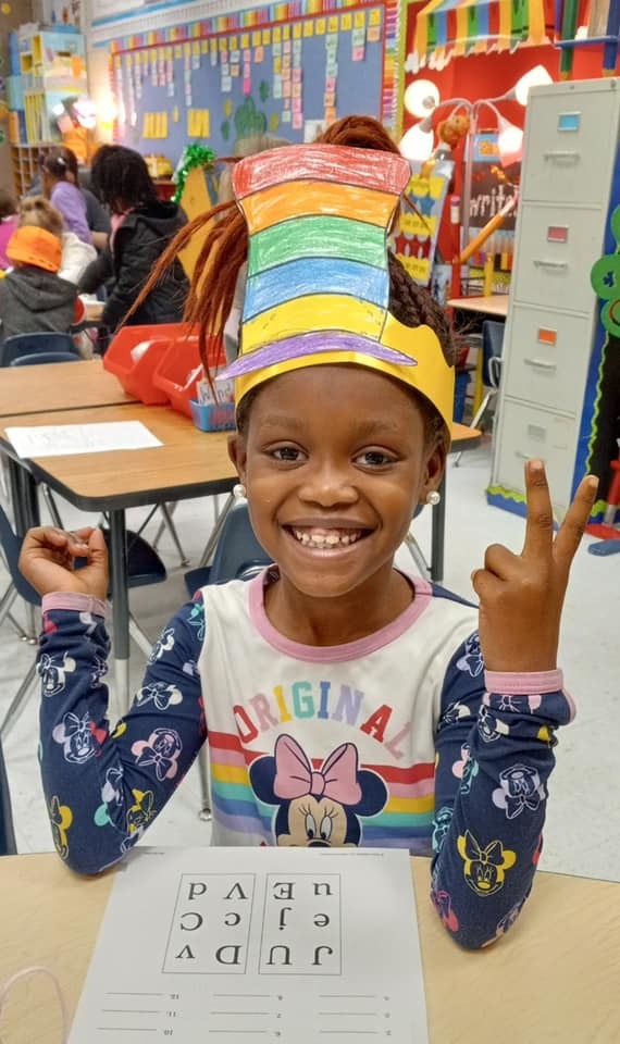 Smiling girl wearing a homemade Dr. Suess hat